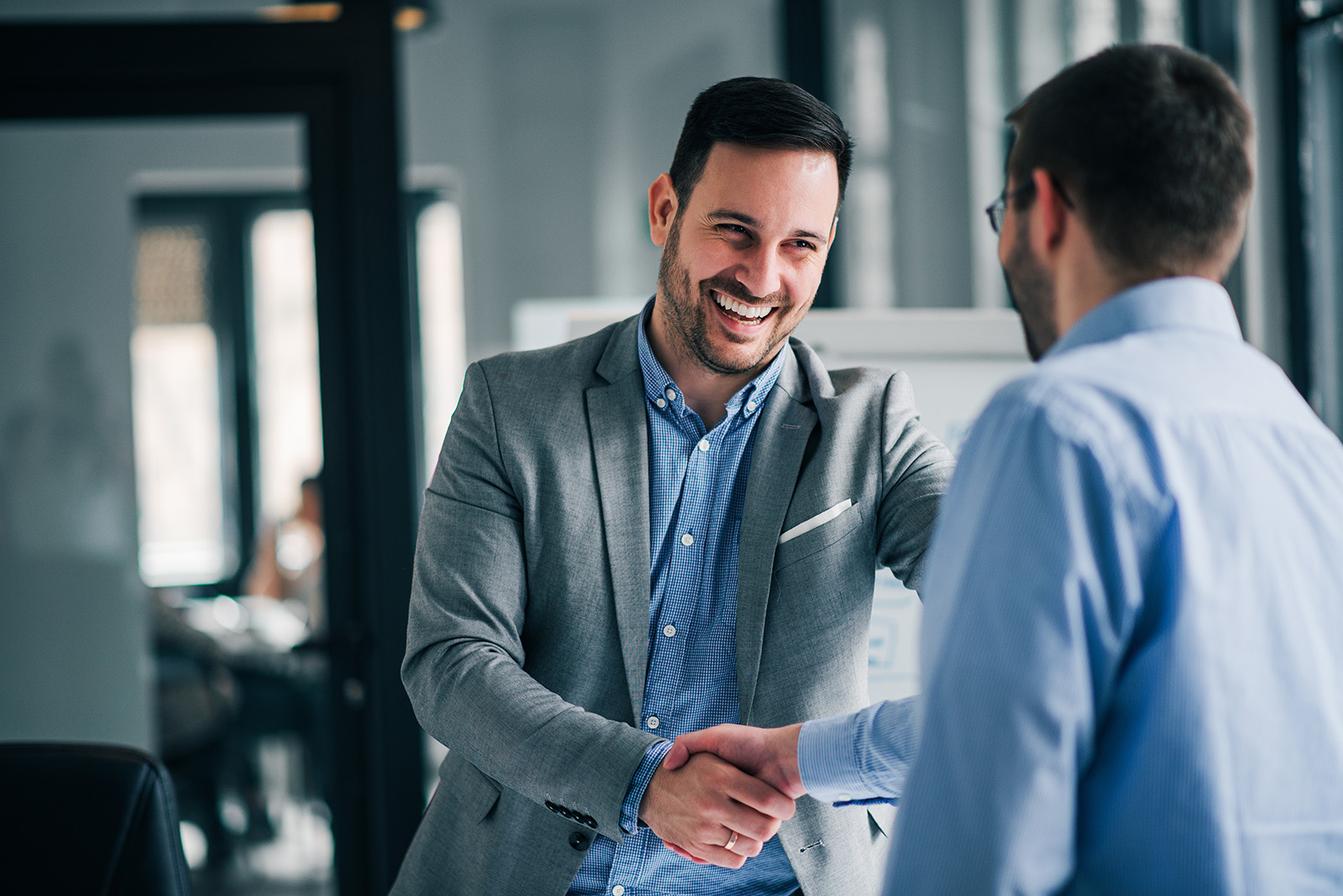 Men shaking hands in an office. 